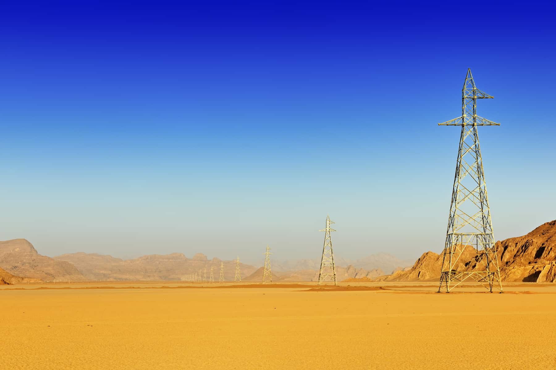 Row of high voltage pylons in the desert of Wadi Rum, Jordan, Middle East ©Pierre Brumder | Adobe Stock Photo